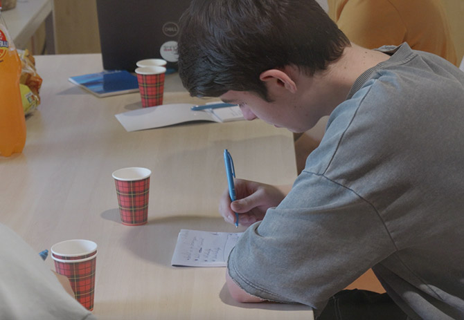 Cursist aan het schrijven achter een bureau